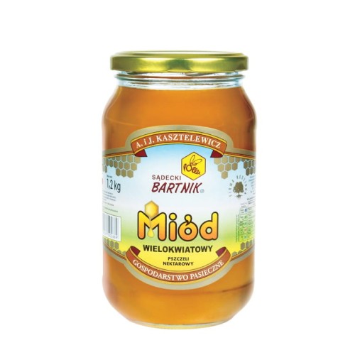 Miód Wielokwiatowy 1,2 kg  - Sądecki Bartnik. Przezroczysty słoik z żółtą zawartością, zielono- żółto-niebieską etykietą ze złotymi komórkami pszczelimi  zawierająca logo, nazwę, producenta, pojemność oraz skład. Złota zakrętka.