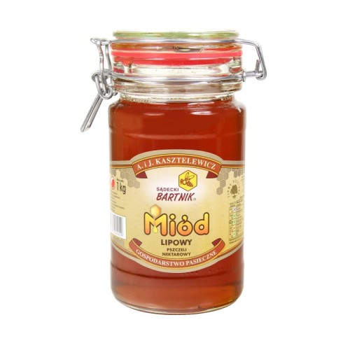Miód Lipowy Komfort - Sądecki Bartnik o pojemności 1 kg. Jasny miód w przezroczystym słoiku z pokrywką zamykaną na klamrę. Słoik posiada beżową etykietę, na której są podstawowe informacje: nazwa, producent, waga, kraj.