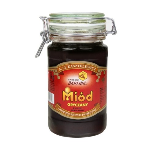 Miód Gryczany Komfort - Sądecki Bartnik  o pojemności 1 kg. Ciemno brązowy miód w przezroczystym słoiku , z pokrywką zamykaną na klamrę. Słoik posiada czerwoną etykietę , na której są podstawowe informacje: nazwa, producent, waga, kraj.