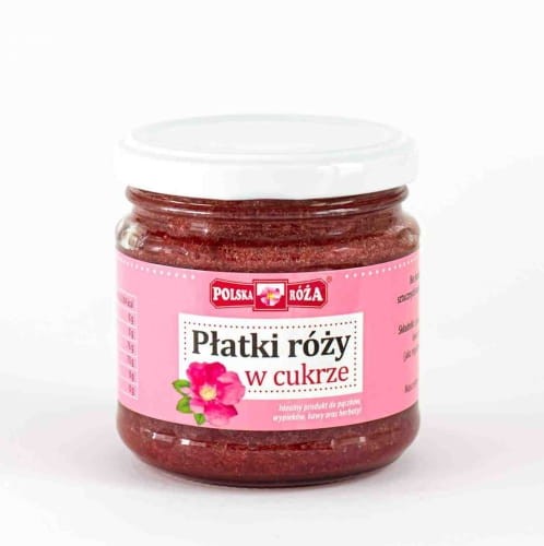 Polska Róża- konfitura z płatki róży w cukrze. Opakowanie 220 gram. Zapakowane w szklany słoiczek z różową etykietą, z wizerunkiem róży na przedzie strony.