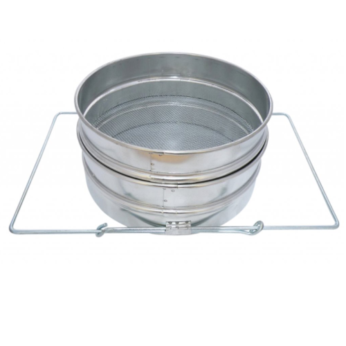 Zdjęcie przedstawia okrągłe, metalowe sito do miodu. Cedzidło jest podwójne z dnem płaskim. Pośrodku znajduje się kwadratowy uchwyt.