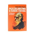 Książka "Pszczelarstwo w zgodzie z naturą , czyli o ewolucji w pasiece" autora Bartłomiej Malety. Zdjęcie wykonane na białym tle. Okładka książki przedstawia starszego pszczelarza. Okładka książki w kolorze pomarańczowym.