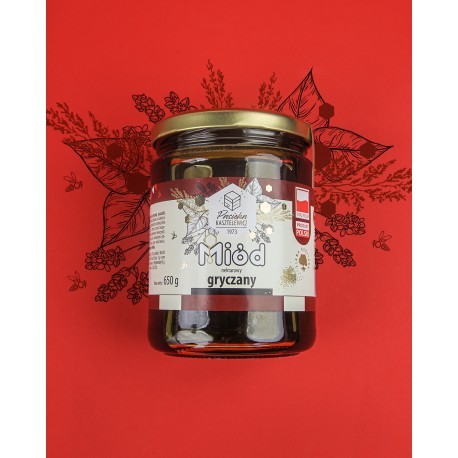 Słoik miodu z serii "Pasieka Kasztelewicz" na czerwonym tle w otoczeniu florystycznego wzoru z pszczołami. Słoik miodu gryczanego ma białą etykietę z złoto-czarnymi wzorami. Pojemność 650g.