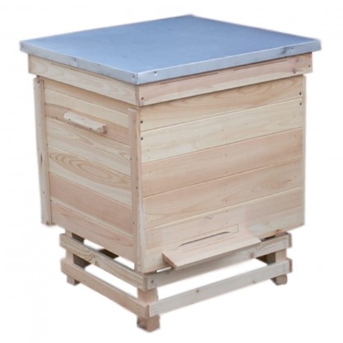 Zdjęcie przedstawia drewniany UL DADANT,  w typie ula LEŻAK DADANT, przedstawionego na stojaku z daszkiem na wierzchu przykrytego blachą.